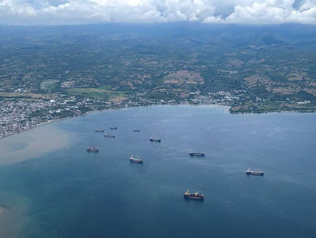 Approaching Sumbawa Besar Airport overlooking the bay with cargo ships.